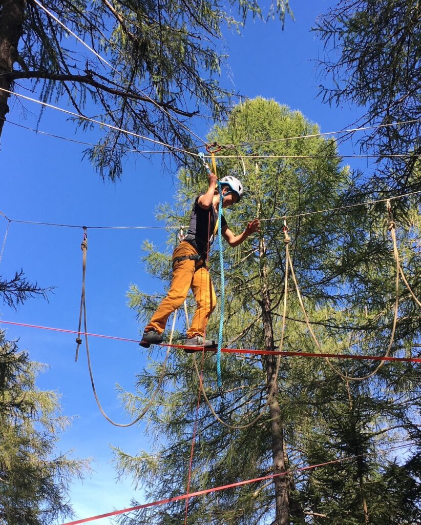 Person beim Klettern in einem Hochseilgarten